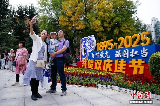 10月2日，校友在天津大学卫津路校区北洋园与建校130周年主题标识合影。 中新社记者 佟郁 摄