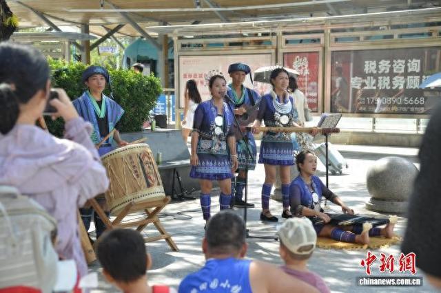10月2日，海南三亚高铁站站前广场上，一场黎族特色的非遗“交响乐”表演吸引游客欣赏观看。张月和 摄