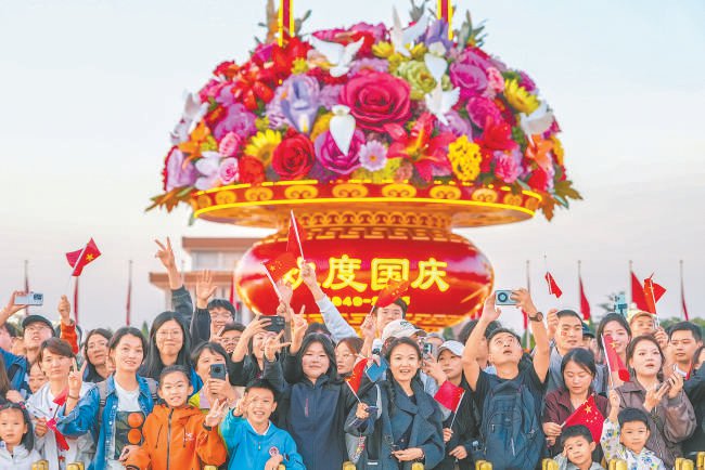 　　国庆假期，市民游客打卡天安门广场大花篮。 本报记者 武亦彬摄