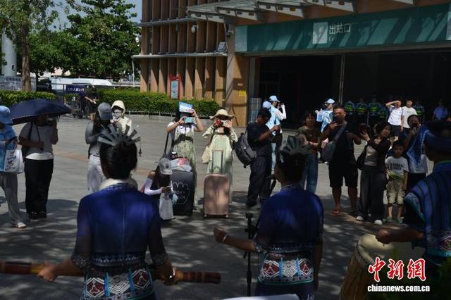 10月2日，海南三亚高铁站站前广场上，一场黎族特色的非遗“交响乐”表演吸引游客欣赏观看。张月和 摄