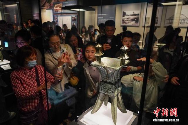 10月1日，国庆中秋假期第一天，位于郑州的河南博物院迎来参观热潮。图为“妇好”铜方斝吸引游客驻足了解。夏青华 摄