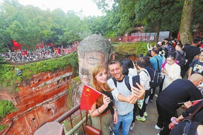 10月1日，外国游客在乐山大佛景区拍照。李华时 摄